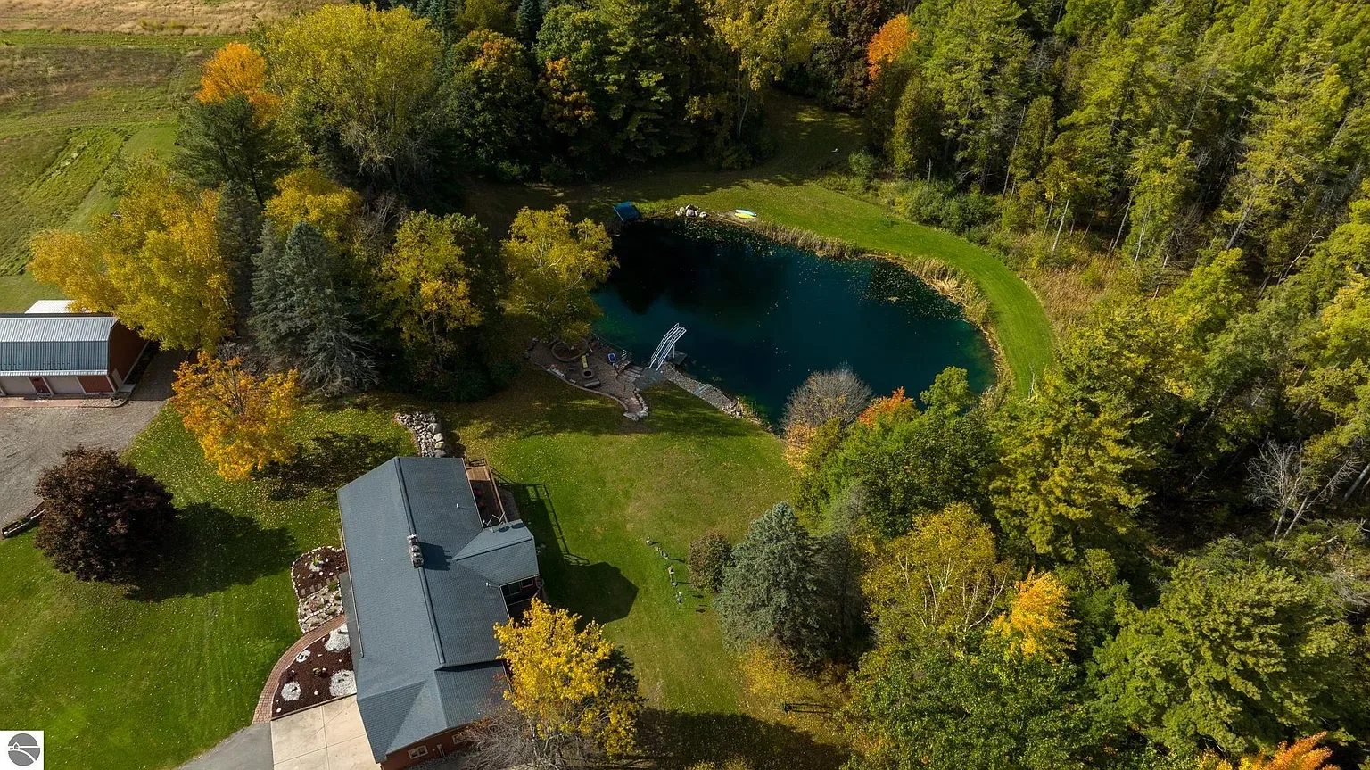 Aerial view of the home, pole barn, pond and surrounding ten acres