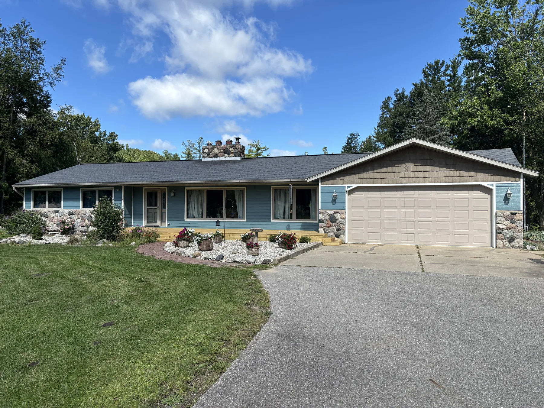 Updated Puddle Blue home exterior, front drive and landscaping beneath a blue sky