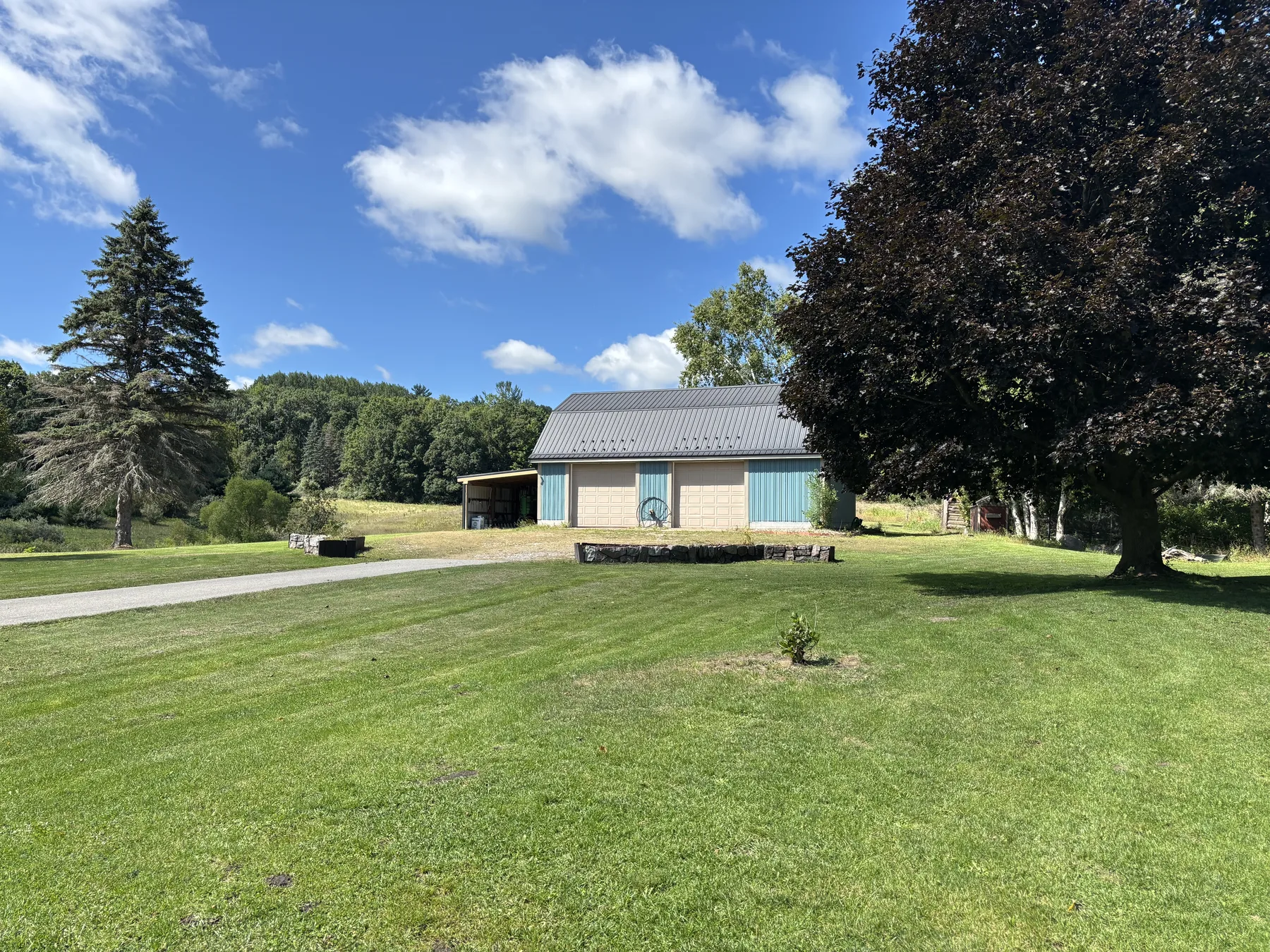 Home, pole barn and open lawn beneath a blue sky