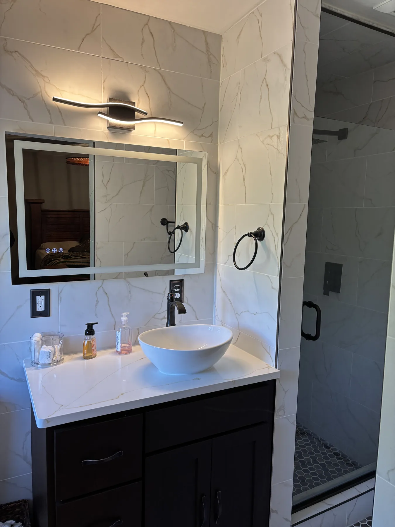 Remodeled hall bathroom vanity with vessel sink, illuminated mirror and quartz countertop